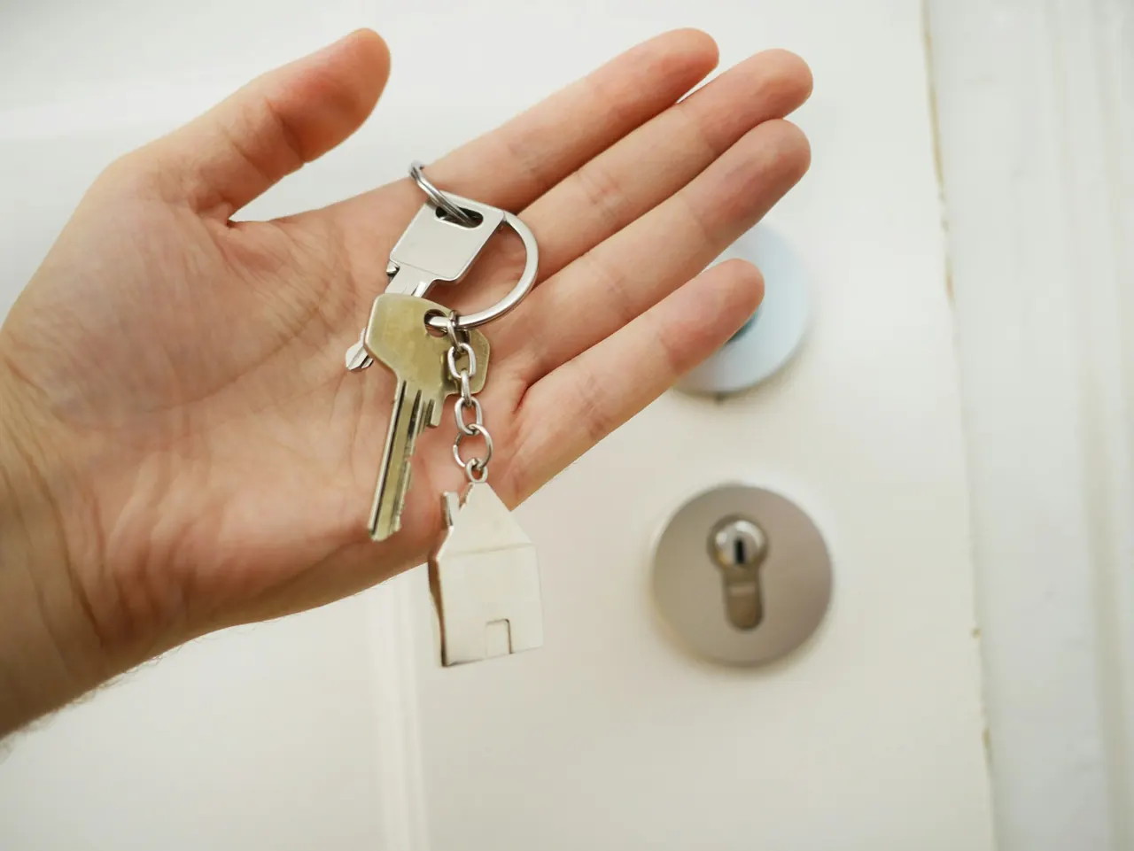 House keys held in front of a front door